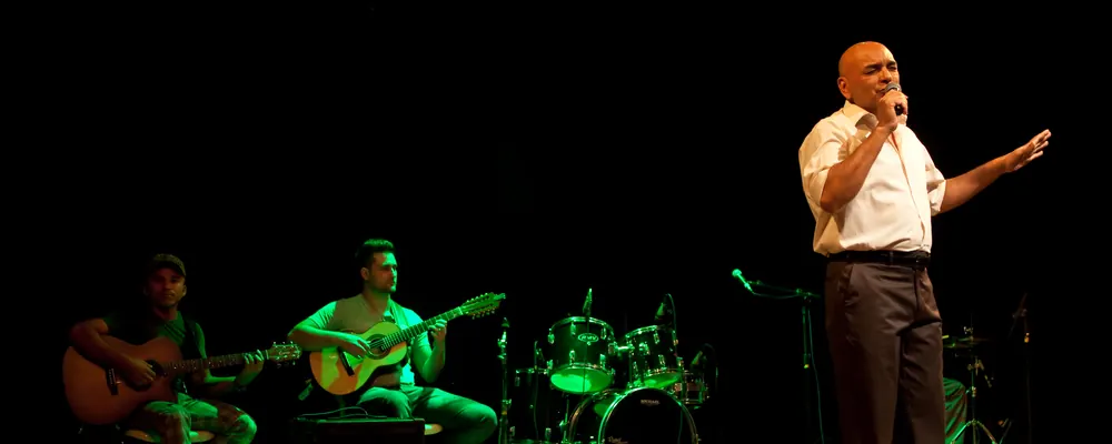 Marcos Fernandes cantando no palco com a banda